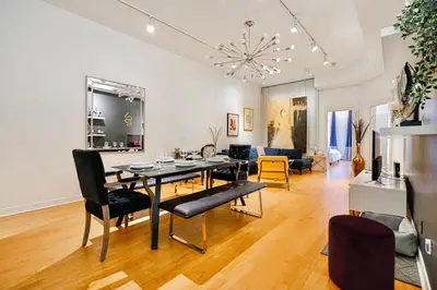 a dining room and living room with a table and chairs at Suite La Madame - Designer Downtown Nest in Montréal