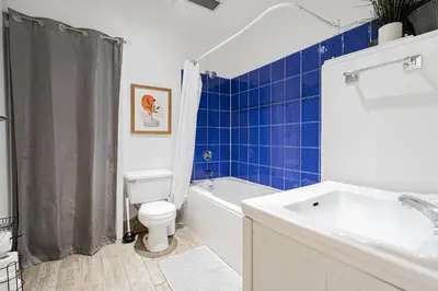 a bathroom with a toilet and a tub and a sink at Suite La Madame - Designer Downtown Nest in Montréal