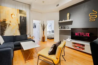 a living room with a couch and a tv at Suite La Madame - Designer Downtown Nest in Montréal