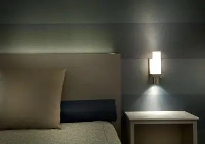 a bedroom with a bed and a table with a lamp at Hôtel-Motel & Suites Idéal Montréal in Montréal