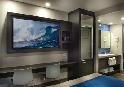 a bathroom with a large painting of a wave on the wall at Hôtel-Motel & Suites Idéal Montréal in Montréal