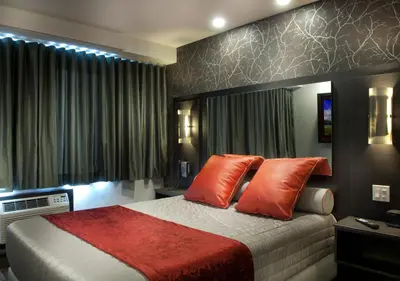 a bedroom with a large bed with orange pillows at Hôtel-Motel & Suites Idéal Montréal in Montréal