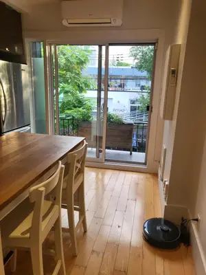 a kitchen with a table and a view of a balcony at Super appartement proche metro in Montréal