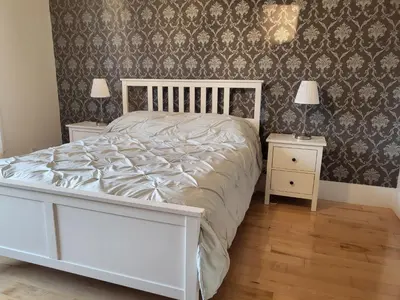 a bedroom with a white bed and two night stands at Super appartement proche metro in Montréal