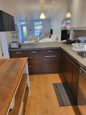 a kitchen with wooden cabinets and a counter top at Super appartement proche metro in Montréal