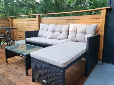 a wicker couch and a table on a patio at Super appartement proche metro in Montréal