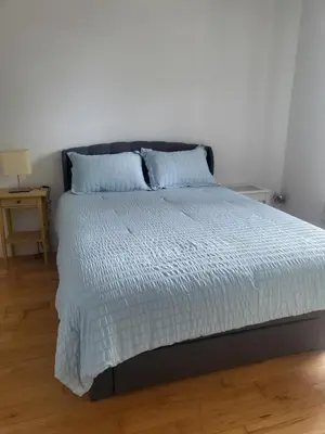 a bedroom with a bed with a white comforter at Super appartement proche metro in Montréal