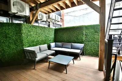 a patio with a couch and a table and a green wall at Yulux Old Montreal luxurious apartments in Montréal