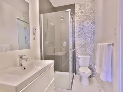 a bathroom with a toilet and a sink and a shower at Yulux Old Montreal luxurious apartments in Montréal