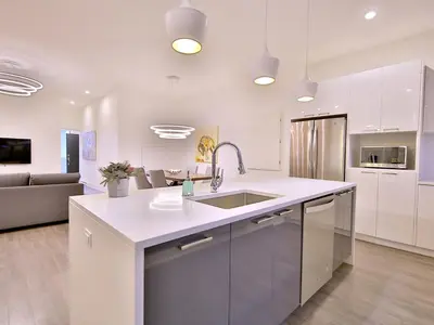 a white kitchen with a sink and a couch at Yulux Old Montreal luxurious apartments in Montréal
