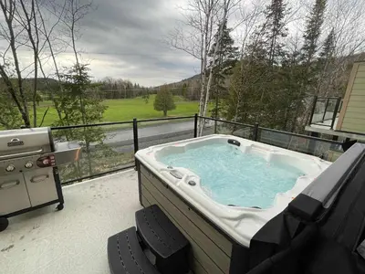 a jacuzzi tub on a balcony with a view at Ski Condo & Spa - L'Elegance Des Sommets in Adstock