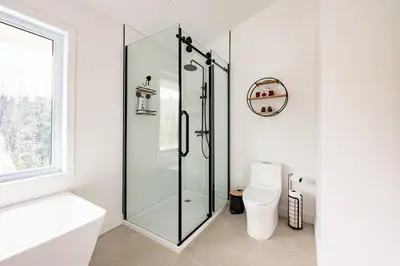 a bathroom with a glass shower and a toilet at Ski Condo & Spa - L'Elegance Des Sommets in Adstock