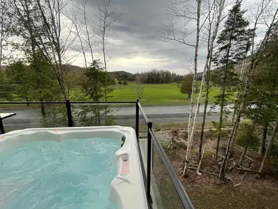 a hot tub on a balcony with a view of a road at Ski Condo & Spa - L'Elegance Des Sommets in Adstock