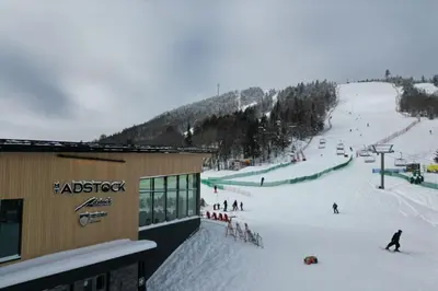 a group of people skiing down a ski slope at Ski Condo & Spa - L'Elegance Des Sommets in Adstock