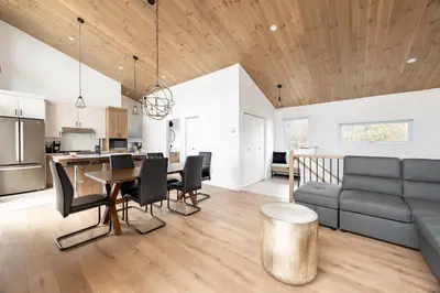 a living room with a couch and a table at Ski Condo & Spa - L'Elegance Des Sommets in Adstock