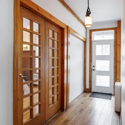a hallway with a wooden door and wooden floors at Downtown Heritage House and Free Parking in Joliette