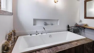a large white bath tub in a bathroom at Downtown Heritage House and Free Parking in Joliette