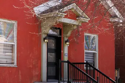 a red house with a black door and windows at Downtown Heritage House and Free Parking in Joliette