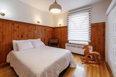 a bedroom with a white bed and a window at Downtown Heritage House and Free Parking in Joliette