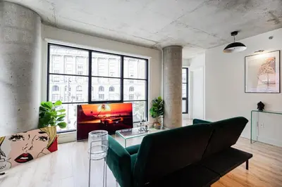 a living room with a green couch and a tv at Old Port Gem - Charming 2 bdr in Prime Location in Montréal