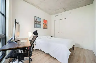 a bedroom with a bed and a desk with a computer at Old Port Gem - Charming 2 bdr in Prime Location in Montréal