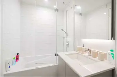 a white bathroom with a sink and a bath tub at Old Port Gem - Charming 2 bdr in Prime Location in Montréal
