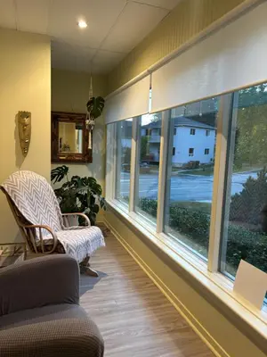 a room with windows and a chair and a couch at le vétérans centrale in Lac-Mégantic
