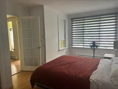 a bedroom with a bed and a window with blinds at le vétérans centrale in Lac-Mégantic