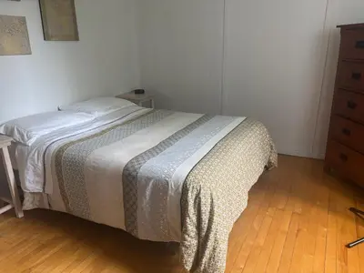 a bedroom with a bed and a dresser at le vétérans centrale in Lac-Mégantic