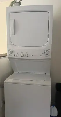 a white microwave sitting on top of a refrigerator at le vétérans centrale in Lac-Mégantic