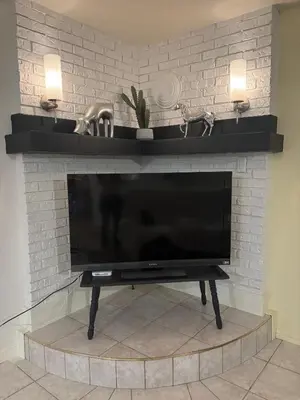a flat screen tv sitting on top of a fireplace at le vétérans centrale in Lac-Mégantic