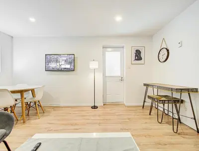 a living room with a table and chairs and a clock at Superbe 2 chambres à Griffintown in Montréal