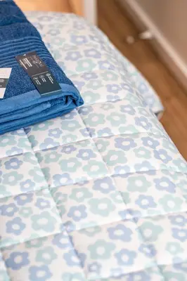 a bed with a blue and white comforter on it at Superbe 2 chambres à Griffintown in Montréal