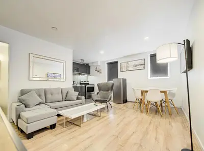 a living room with a couch and a table and chairs at Superbe 2 chambres à Griffintown in Montréal