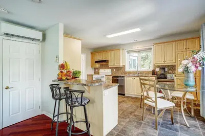 a kitchen with wooden cabinets and a table and chairs at Sutton's montagne view in Sutton