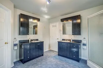 a bathroom with two sinks and two mirrors at Sutton's montagne view in Sutton