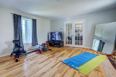 a living room with a hard wood floor and a tv at Sutton's montagne view in Sutton