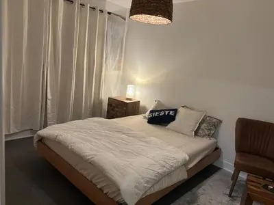 a bedroom with a bed and a chair at Cosy Cabin apt in Montreal in Montréal