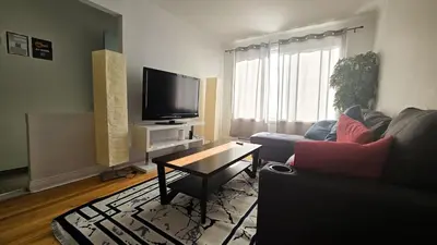 a living room with a couch and a tv at Private rooms in a shared three bedroom apartment in Montréal