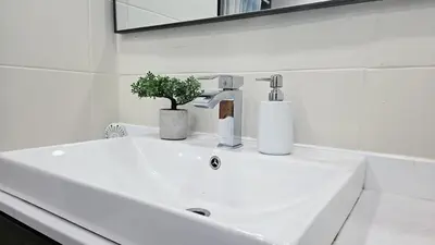 a white bathroom sink with a plant on it at Private rooms in a shared three bedroom apartment in Montréal