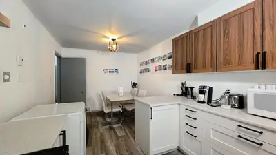 a kitchen with white cabinets and a table with a microwave at Private rooms in a shared three bedroom apartment in Montréal