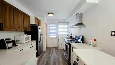 a kitchen with white counters and a black refrigerator at Private rooms in a shared three bedroom apartment in Montréal