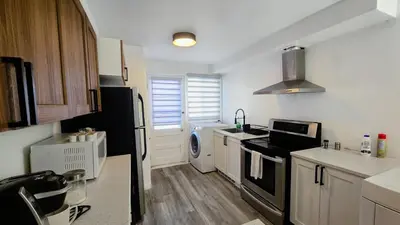 a kitchen with a sink and a stove top oven at Private rooms in a shared three bedroom apartment in Montréal