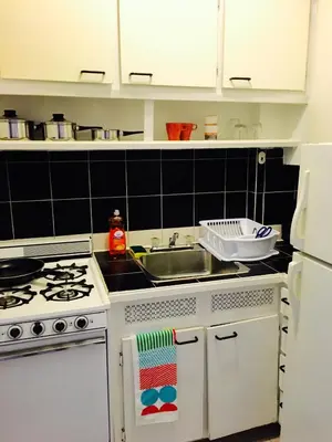a kitchen with a white stove and a sink at Stylish Montreal Apartment Comfortable Stay in the Golden Square Mile in Montréal