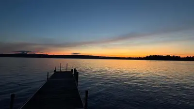 a dock on a body of water at sunset at La Brise O-Lac in Sherbrooke
