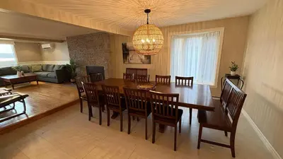 a dining room and living room with a table and chairs at La Brise O-Lac in Sherbrooke