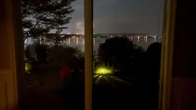 a window with a view of the water at night at La Brise O-Lac in Sherbrooke