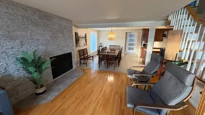 a living room with a fireplace and a dining room at La Brise O-Lac in Sherbrooke