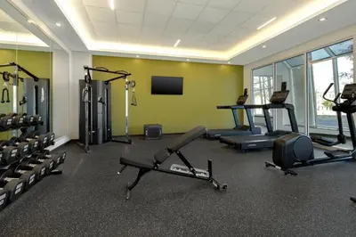a gym with several treadmills and machines in a room at Spark By Hilton Montreal Midtown in Montréal