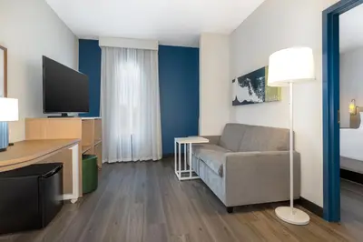 a living room with a couch and a tv at Spark By Hilton Montreal Midtown in Montréal